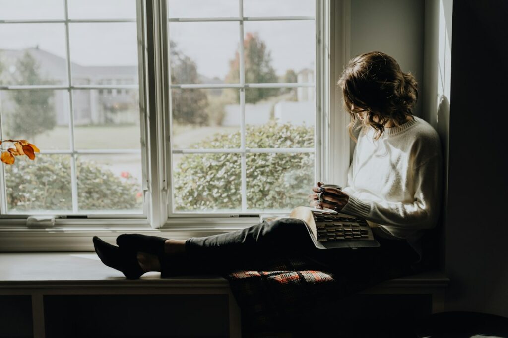 Woman sitting quietly by a window at home