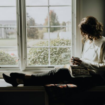 Woman sitting quietly by a window at home